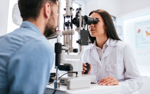 Female eye doctor performing eye exam on male patient