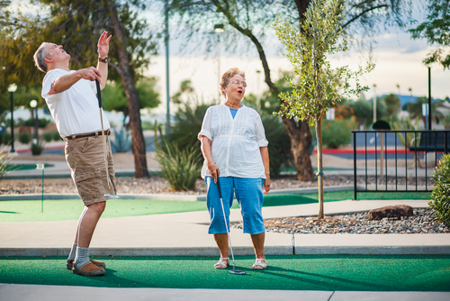 older couple playing mini golf