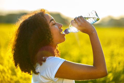 woman drinking from water bottle